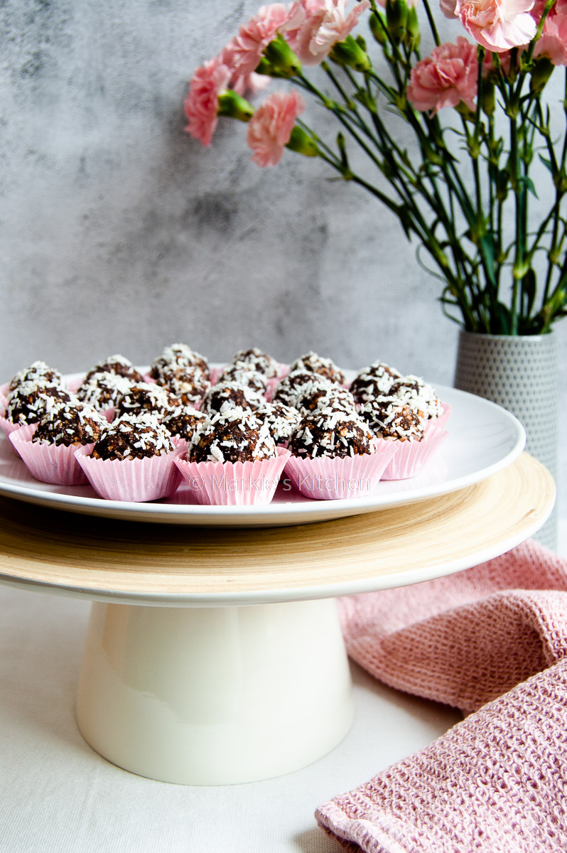 picture of no-bake coconut and chocolate balls served in paper cups on a cake stand