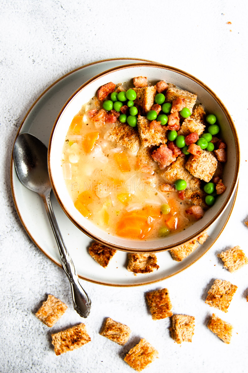 Hearty yellow pea soup with carrots, onion, green peas and pancetta, served with bread croutons.