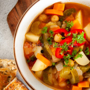 vegetable and chickpea soup in a bowl served with toasted bread
