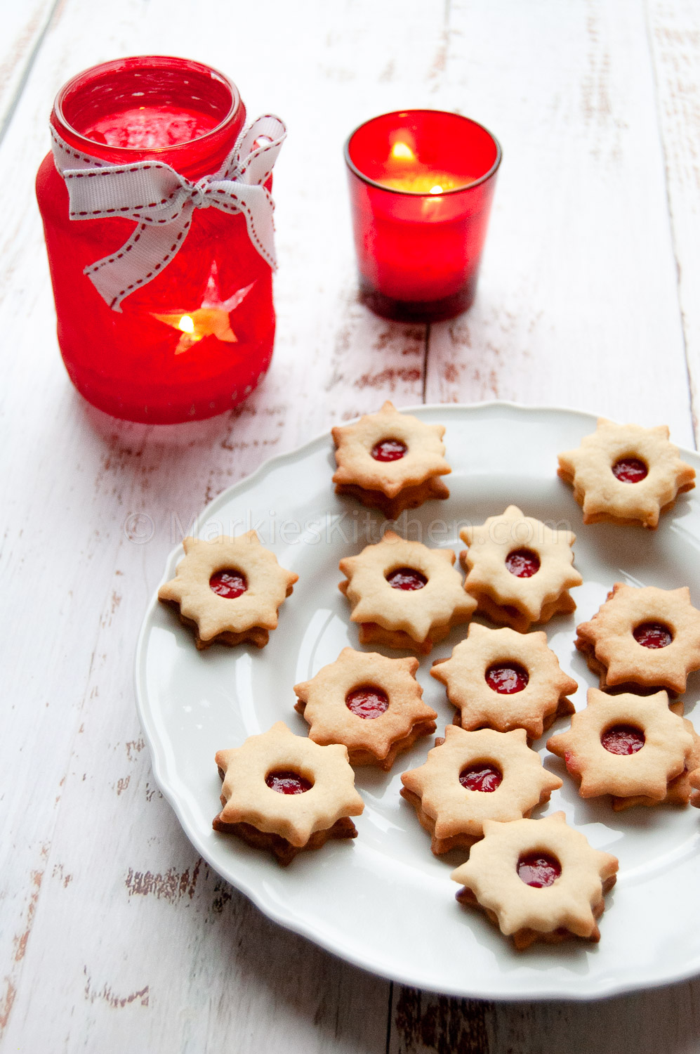 serving idea: linzer cookies on a plate next to two candle holders