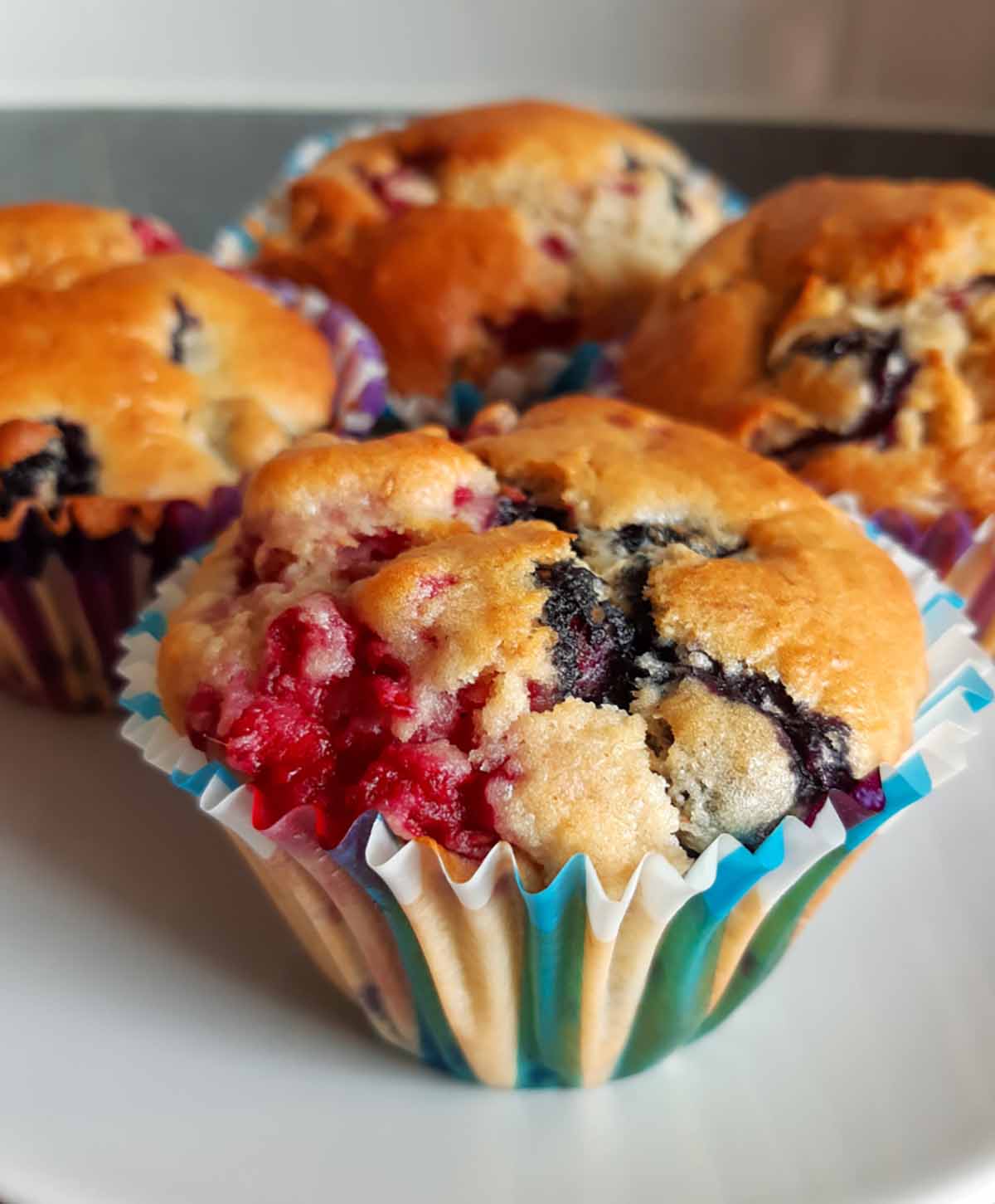 A close up photo of oat berry muffins in paper cups.